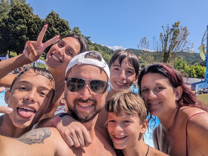 a group of people taking a selfie in front of a swimming pool