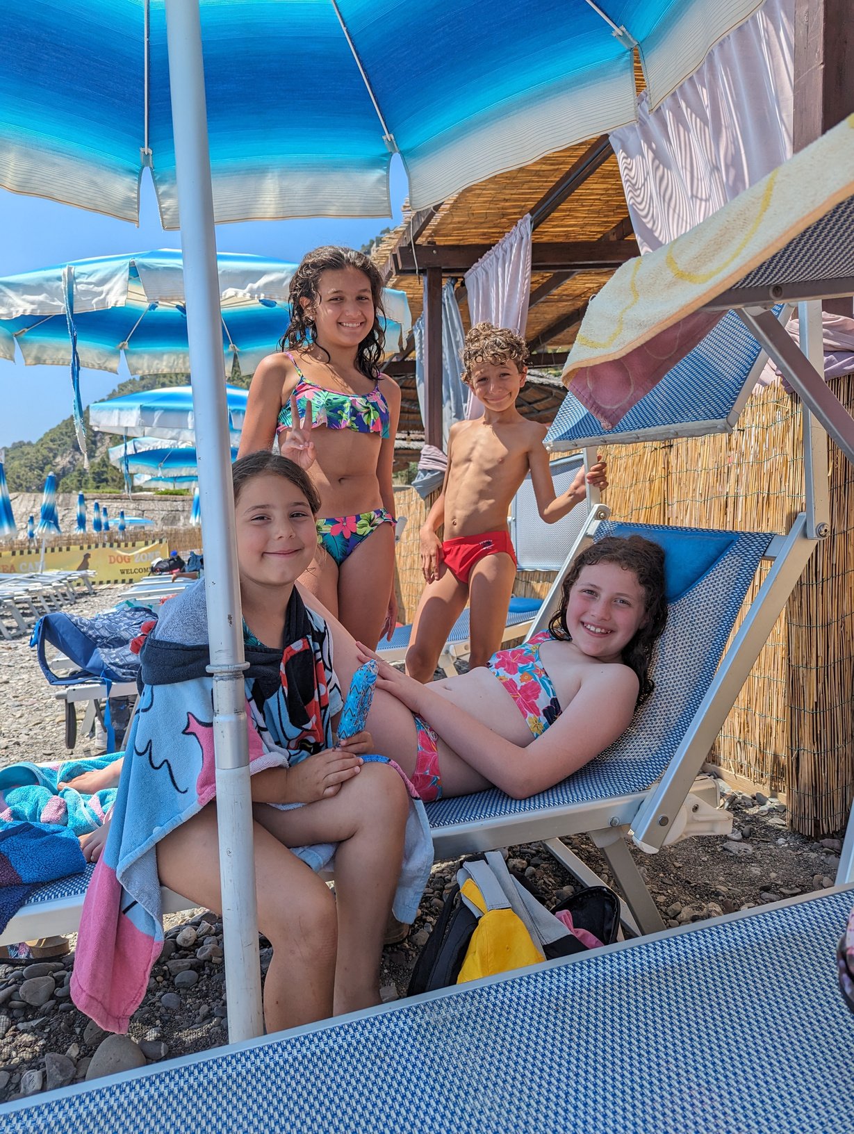 a group of children on the beach with umbrellas